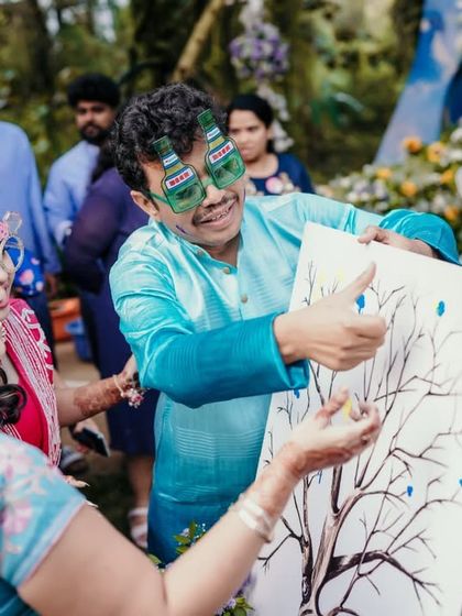A guest having fun with a drawing game during the Haldi party festivities.
