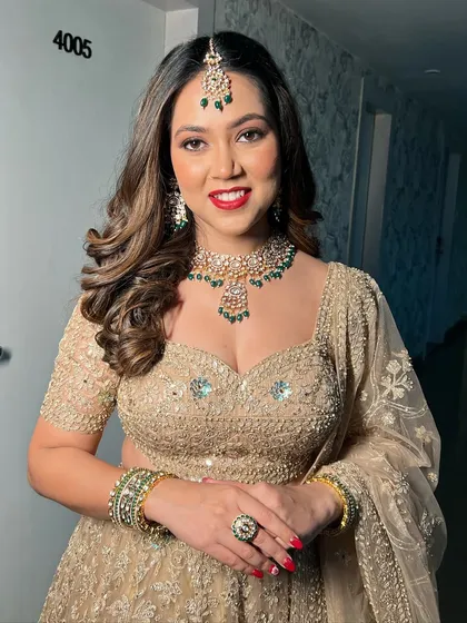 The complete reception look, showcasing the beautiful golden lehenga and emerald jewellery.