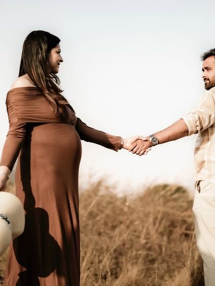 A wide shot of the couple holding hands in a golden field, looking at each other. The vast landscape emphasizes the beginning of their new journey.