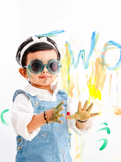 This little artist is ready for her close-up. The paint on her hands and face, paired with cool sunglasses, shows off her fun and quirky personality.