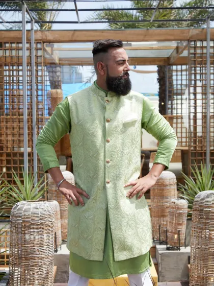 A confident stance in the pastel green waistcoat set. The intricate details and heritage craftsmanship make this a standout piece for any festive occasion.