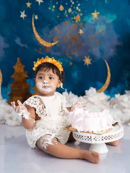 Let's make a mess! A first birthday cake smash is pure, unfiltered joy. This little star, covered in frosting against a magical moon and stars backdrop, is having the time of her life, and I love capturing every sweet moment.
