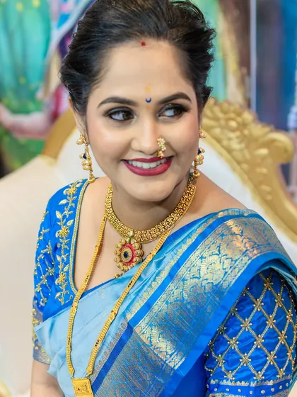 A close-up capturing her joyful expression and the details of her makeup, including the classic bindi and winged eyeliner.