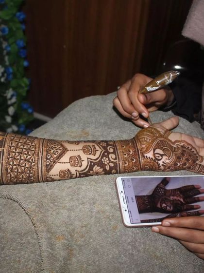 Here you can see my process of creating a custom design, referencing a photo on the phone to draw the intricate peacock motif freehand.