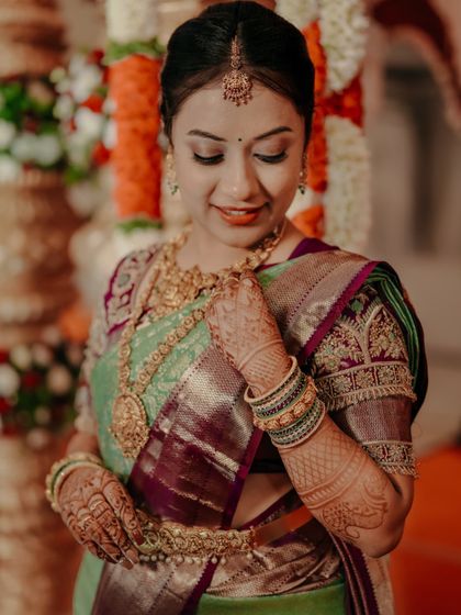 A bride adjusting her necklace, a simple and elegant candid moment.