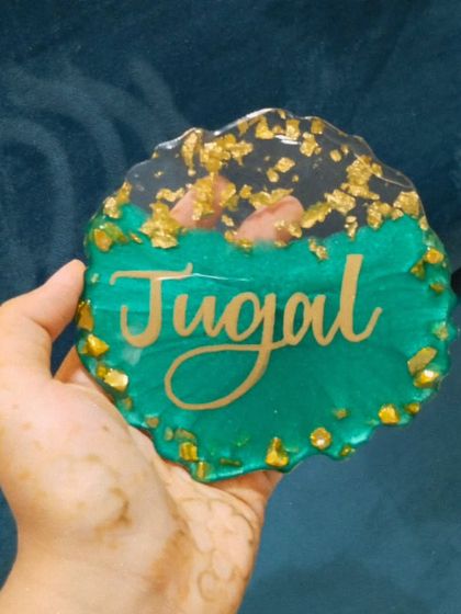 A different angle of the 'Jugal' name plaque, showing the texture of the gold flakes.