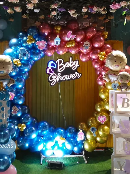 This wide shot shows the complete baby shower decoration setup. The large balloon ring, neon sign, and side elements come together to create a grand and impressive backdrop for your special day.