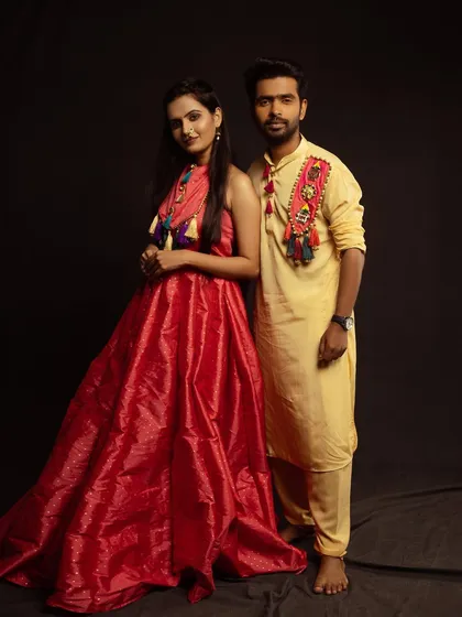 A full-length studio portrait of a couple in stylish fusion wear, standing together with a confident and modern look.