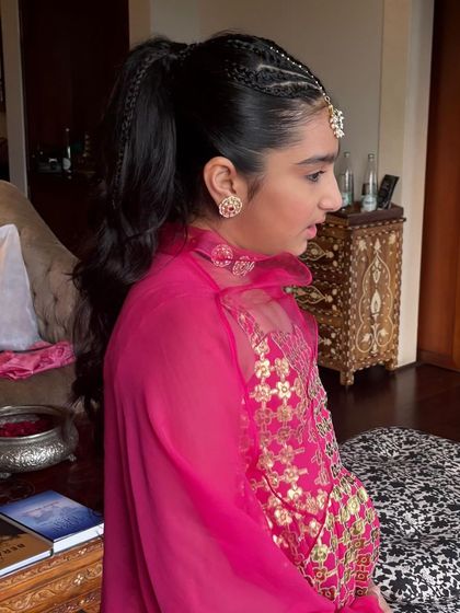 A side view of the textured ponytail on a younger client. The style is youthful and fun, with cornrow-style braids at the top leading into a wavy ponytail.