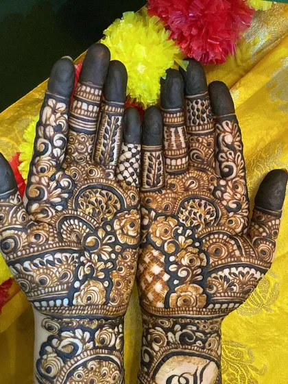A close-up of the palms, with filled fingertips, a traditional bridal choice.