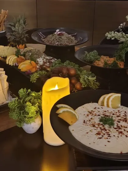 A beautiful candlelight setting for an evening event, featuring our signature hummus and a lavish grazing board.