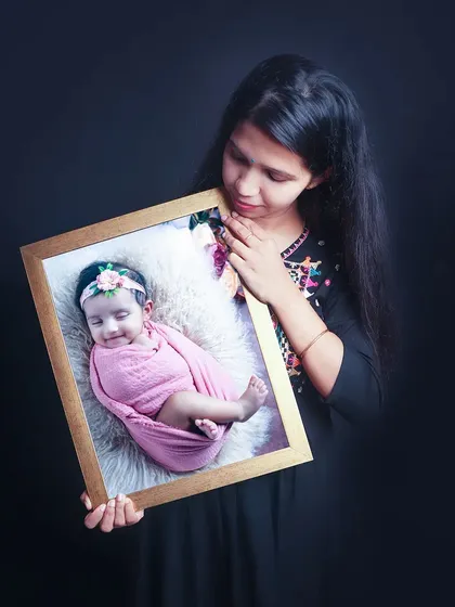 Another example of a finished product, with a mother holding a framed portrait of her baby girl. I offer custom framing and albums to turn your digital photos into lasting art.