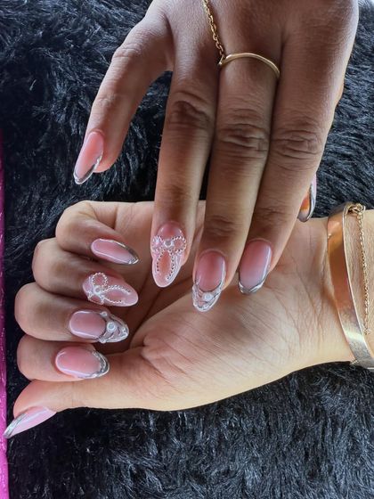 Intricate and delicate, this design is perfect for a sophisticated look. It features fine, lace-like white detailing over a sheer pink base, outlined with a thin silver chrome line.