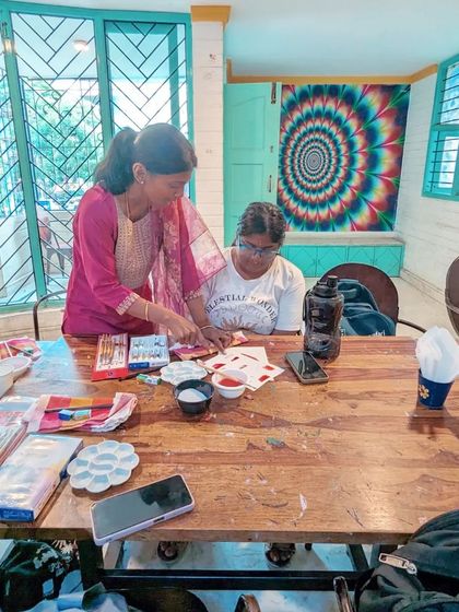 The instructor providing one-on-one guidance to a participant during the workshop, helping her bring her artistic vision to life.