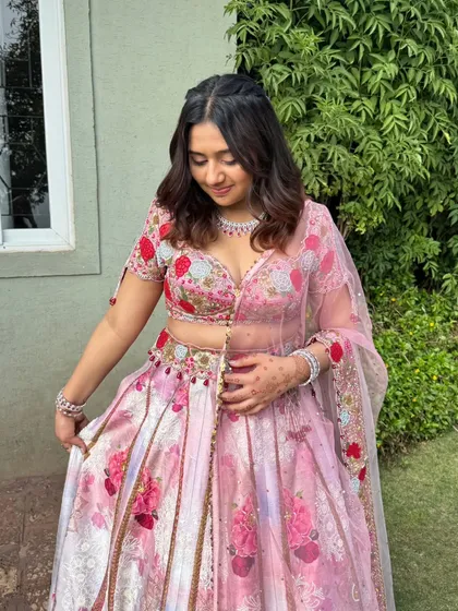 A candid moment showing the beautiful details of the lehenga and the soft, romantic makeup.