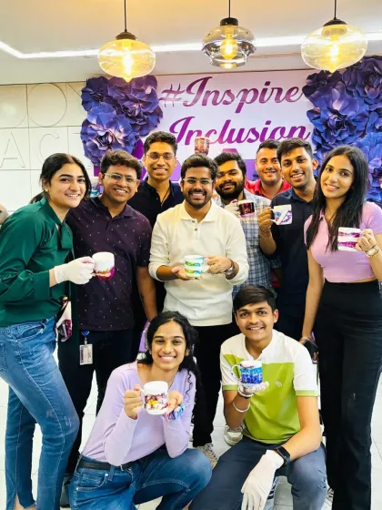 Work hard, create harder. This team proudly shows off the custom mugs they designed during a corporate workshop, a great way to foster creativity and teamwork in the workplace.