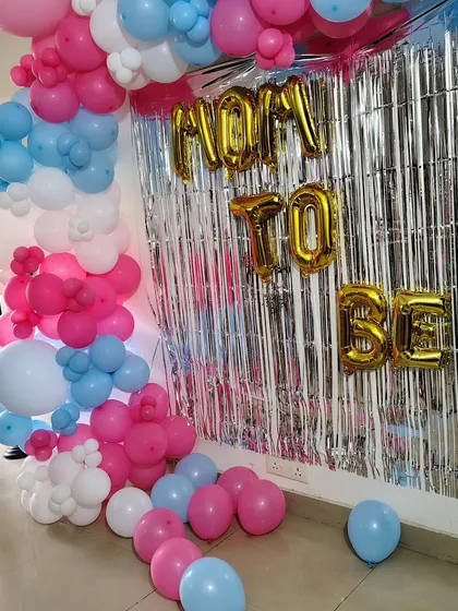 Another angle of the 'Mom to Be' backdrop, showing how the balloon garland frames the foil letters and curtain.