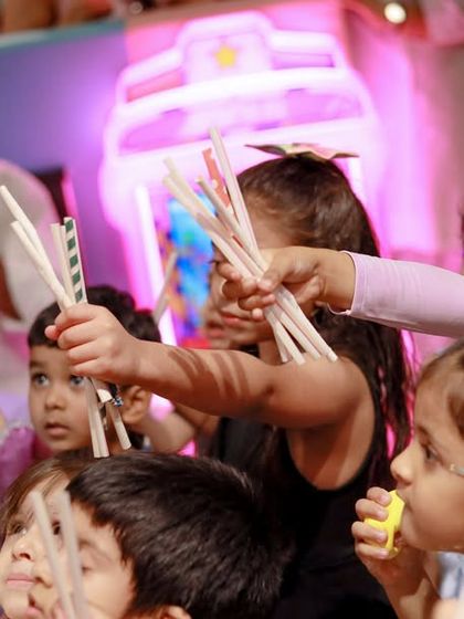 Children watch the magic show with rapt attention, wands in hand. We can provide themed props to make the experience even more immersive.