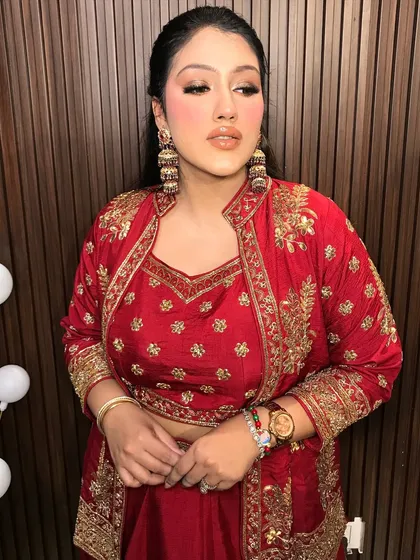 A final portrait of the client, looking absolutely radiant in her red outfit and gold jhumkas.