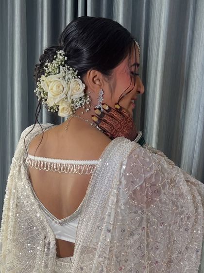 Another angle of the beautiful hairstyle, showing the intricate details of the bun and floral placement.