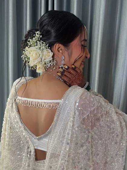 Another angle of the beautiful hairstyle, showing the intricate details of the bun and floral placement.