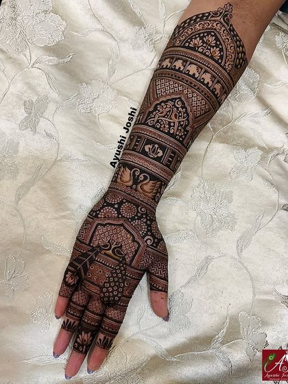 A full arm design for Karva Chauth, packed with traditional elements like peacocks, swans, and elephants.