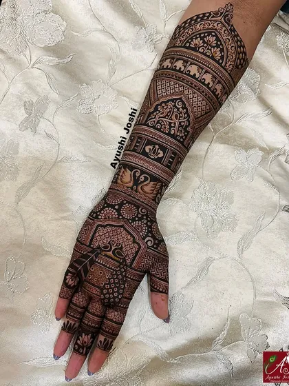 The full Karva Chauth design, combining the intricate armband with beautiful patterns on the hand, including peacocks and swans.