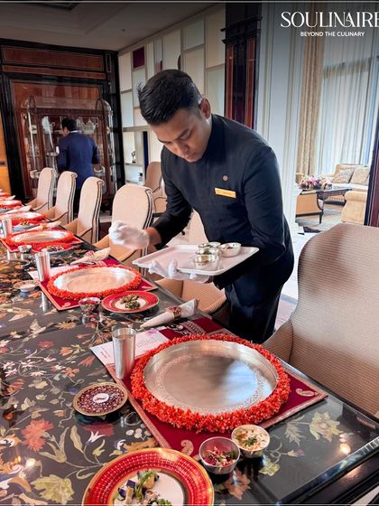 A server setting up a traditional silver thali for an exclusive sit-down meal. We are adept at executing both modern and traditional service styles with finesse.