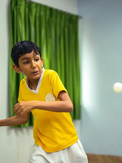 A fierce and focused expression from one of our young table tennis players during an intense rally.