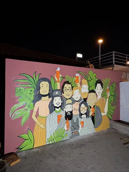 A wide shot of the finished mural at night. It creates a lively atmosphere for this outdoor space.