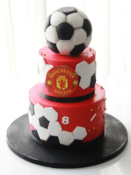 A three-tiered Manchester United themed cake for an 8th birthday, celebrating a love for the Red Devils.