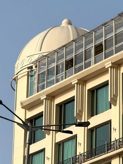 The domed roof of an Art Deco building, its geometric patterns standing out against the sky.