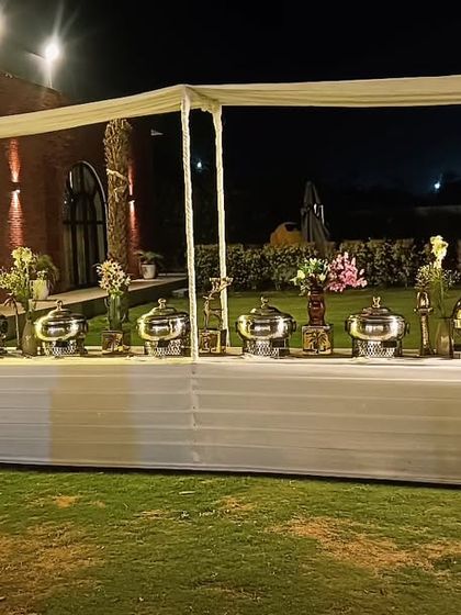 An elegant outdoor buffet setup for an engagement function for 85 guests. The clean lines, fresh floral decor, and professional arrangement ensure a sophisticated dining experience.