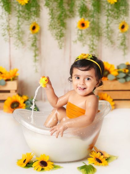 Playing with a rubber ducky in her sunflower milk bath. It's these simple, classic moments of play that create the most cherished memories.