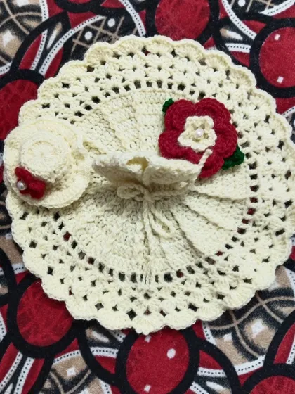 This beautiful off-white poshak comes with a matching hat and is adorned with a single red flower. It is a simple and graceful design for your Laddu Gopal.