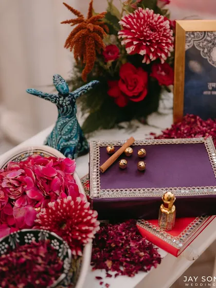 The details of a Mehfil-e-Mehendi. This flat lay includes a miniature whirling dervish figurine, fragrant ittars, and ornate boxes, all carefully chosen to evoke a sense of tradition and artistry.