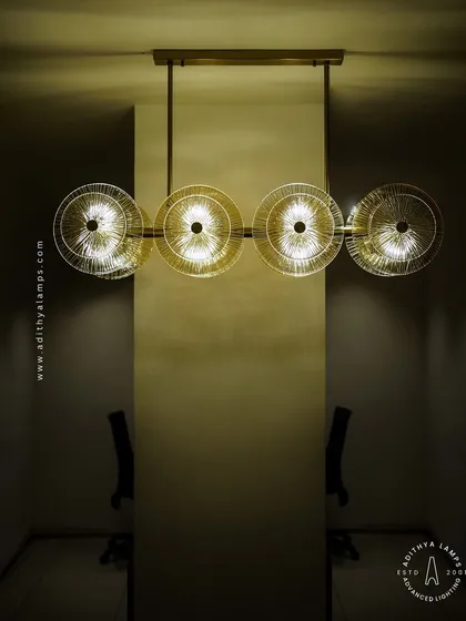 A perfect lighting solution for over a dining table or conference table. This linear chandelier features a series of textured glass discs on a gold frame, diffusing light beautifully to create an inviting and elegant atmosphere.