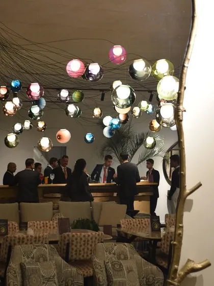 A reflection of the Bocci 28 series installation in a mirror, creating an illusion of infinite depth and complexity. This shows how lighting can be used to play with perception and space.