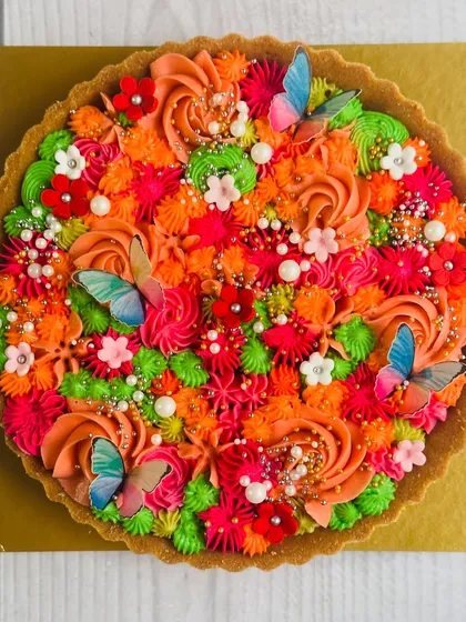My bestselling chocolate tart, adorned with a vibrant explosion of colorful buttercream and edible butterflies. It's a feast for the eyes and a delight for the taste buds.