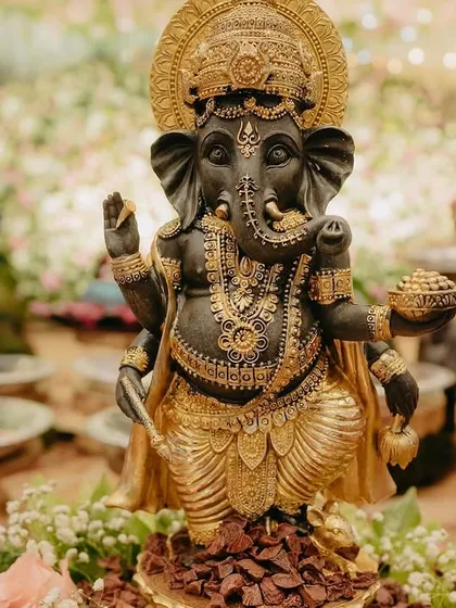 A close-up of the majestic black and gold Ganesha idol used as a centerpiece.
