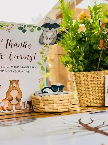 A "Thanks for Coming" sign at the woodland party, encouraging guests to leave their fingerprint and sign their name as a keepsake.