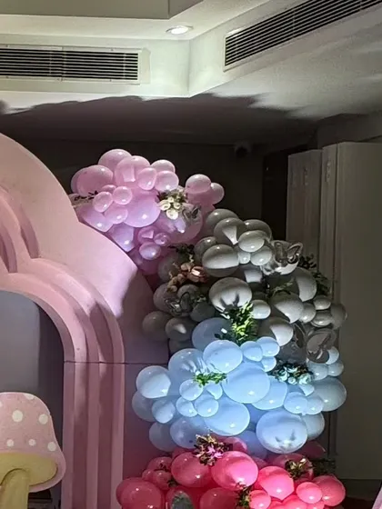 A multi colored balloon arrangement in pink, blue, and silver.