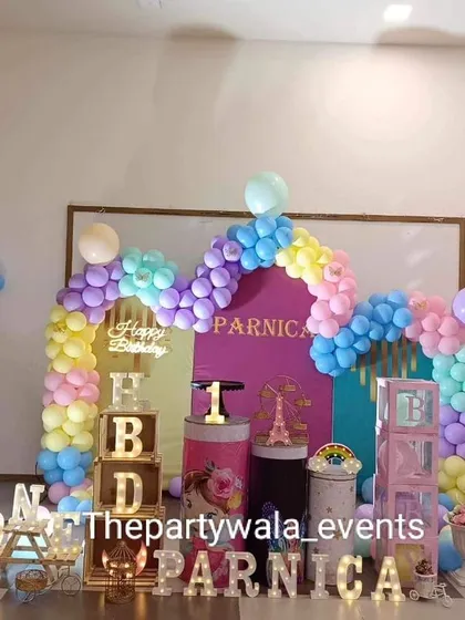 A colorful fairy tale theme with a rainbow balloon arch and "HBD" blocks. This setup is perfect for a bright and cheerful first birthday party.