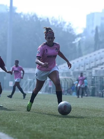 A player on the attack, driving forward with the ball at her feet.