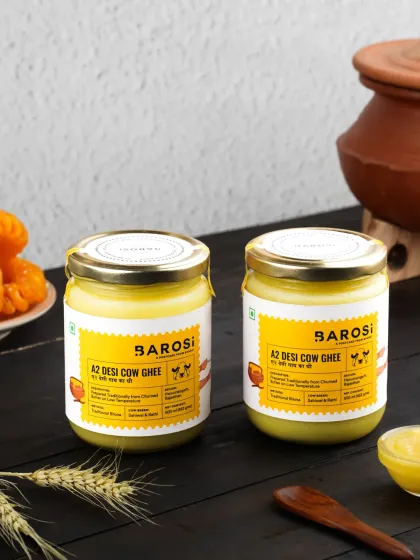 Two jars of A2 Desi Cow Ghee styled with a dark, rustic background, creating a moody and premium feel for the product.