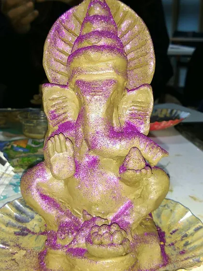 A Ganesha idol decorated with vibrant glitter. Students are always encouraged to add their own personal touches to make their creations truly their own.
