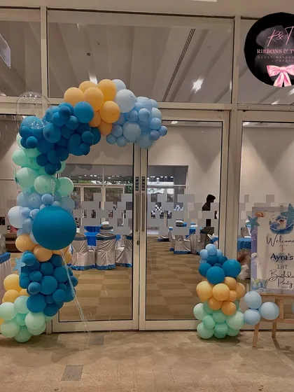 The entrance to the underwater adventure, featuring a balloon arch in shades of blue and orange and a personalized welcome sign for baby Ayra.