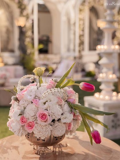 A beautiful floral arrangement of pink and white roses and tulips, a key detail that added softness and romance to the elegant wedding decor.