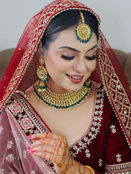 A candid shot of the bride smiling, capturing her natural beauty enhanced by the makeup.