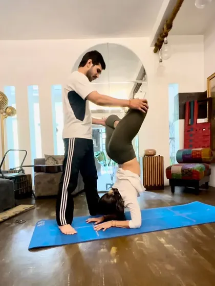 A different angle of the Lotus Forearm Balance assist, showing how I help stabilize the pelvis.